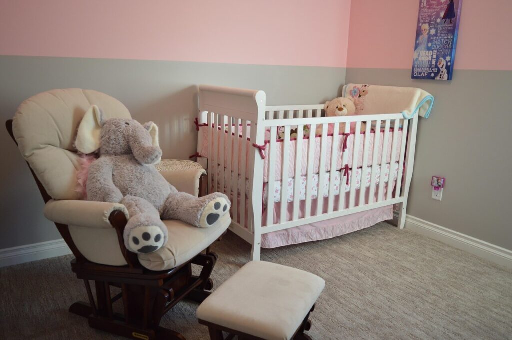 赤ちゃん用ベッドとぬいぐるみが置かれた温かみのある子ども部屋の一角